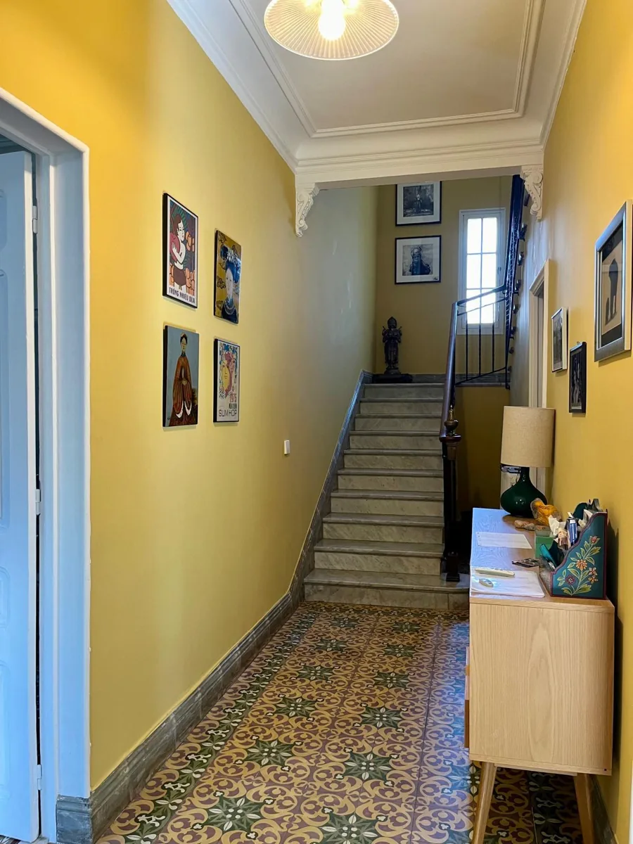 Après : couloir et escalier repeints en jaune, moulures et plafond blancs