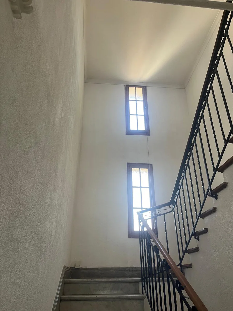 Avant : cage d'escalier aux murs blancs défraîchis